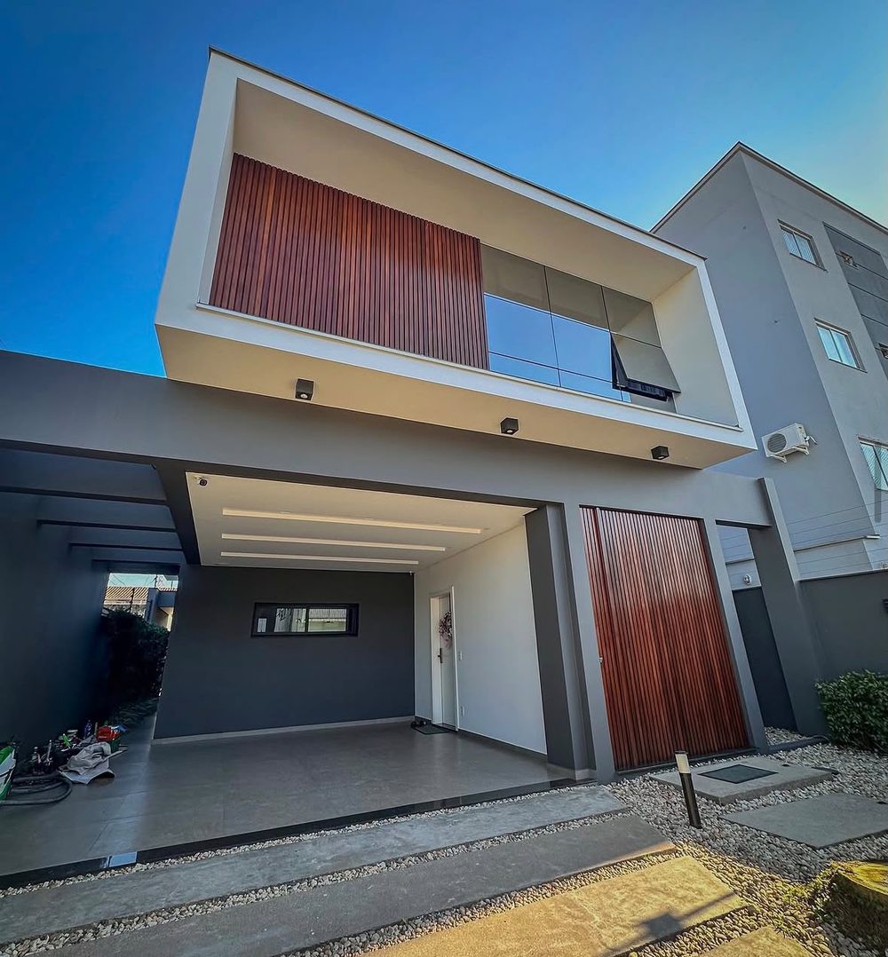 Fachada residencial entregue pela Nova Fachada Pinturas: sobrado com pintura completa, acabamento em madeira e área externa pronta